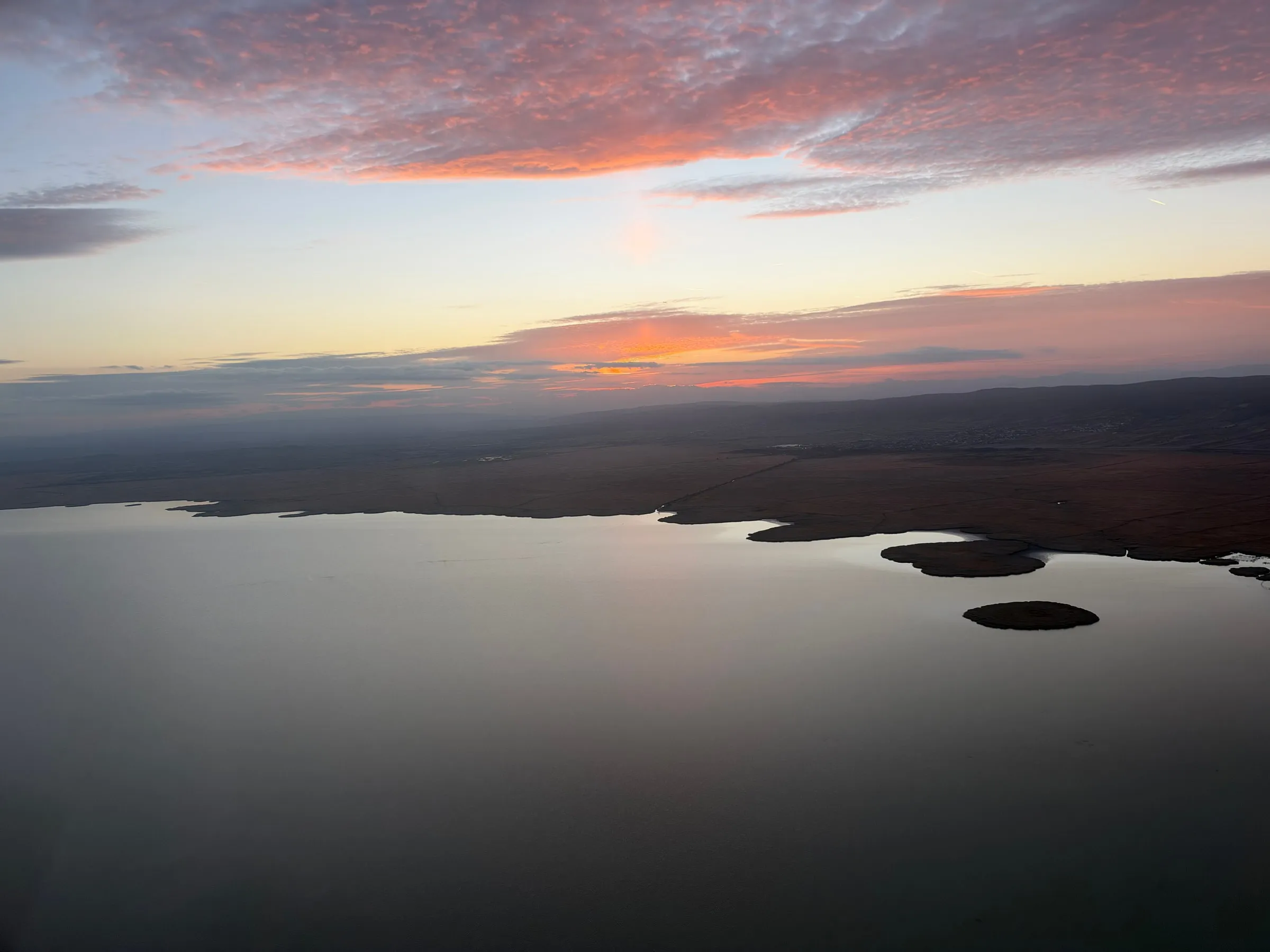 Lake Neusiedl and small islands beneath a colourful evening sky